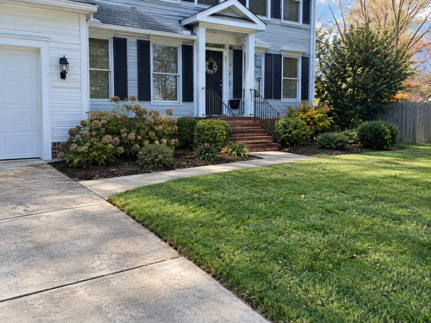 Front entry landscaping and mowed lawn beside a walkway